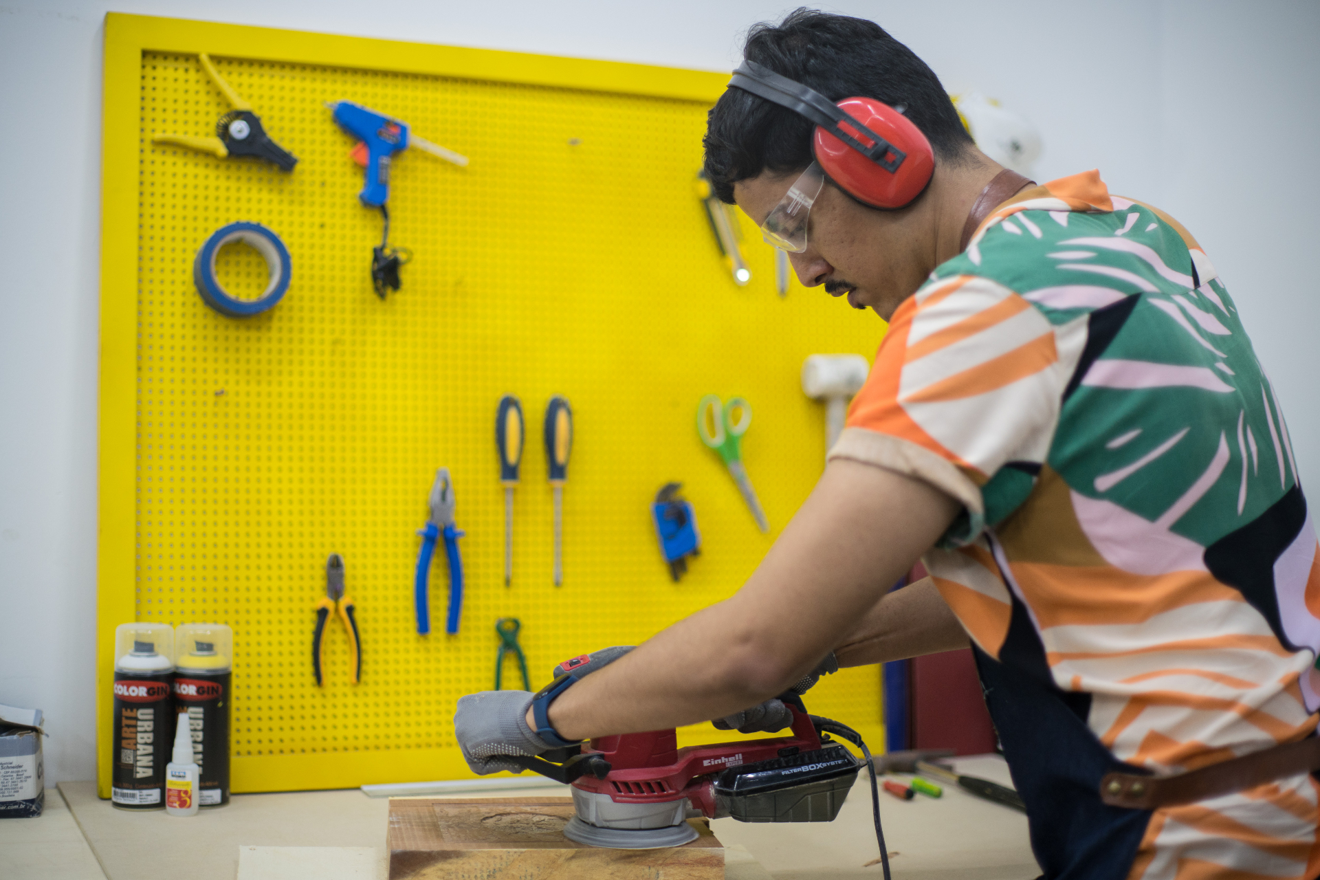 Participante em oficina prática de cultura maker e prototipagem com lixadeira, equipamentos e ferramentas